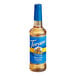 A close up of a Torani Sugar-Free English Toffee flavoring syrup in a 750 mL plastic bottle with a blue label.