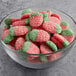 A bowl of Vidal sour gummy strawberries on a table.