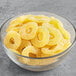 A close-up of a bowl filled with yellow Vidal Gummy Pineapple Rings.