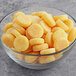 A bowl of Vidal yellow and orange round candies.