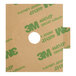 A white circle with green and white writing on a brown cardboard box.