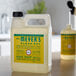 A white plastic jug of Mrs. Meyer's Clean Day Honeysuckle Scented Hand Soap with a yellow label on a counter.