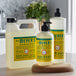 A white Mrs. Meyer's Clean Day honeysuckle scented liquid soap refill jug with a yellow label on a wooden counter.