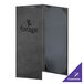A black customizable menu cover with a grey interior on a table in a farm-to-table restaurant.