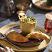 A Libbey tan terracotta bouillon bowl filled with soup on a table.