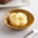 A Le Gall unsalted butter portion in a small bowl on a table.