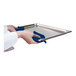 A person using an Araven blue silicone pot holder to hold a metal tray.