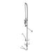 A chrome deck-mounted pre-rinse faucet with a hand held sprayer hose.