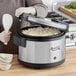 A person using an Avantco rice pot to cook rice in a rice cooker.