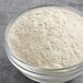 A bowl of Premier Protein vanilla milkshake protein powder on a table.