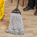 A Lavex blue and white mop head cleaning a wood floor.