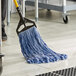 A person cleaning a floor with a blue Lavex mop.