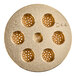 A circular gold Estella Capellini pasta die with holes in it.