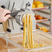 A person using an Estella #21 linguine pasta die in a pasta machine.