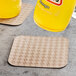 A glass of orange juice on a Hoffmaster EcoWave Kraft coaster.