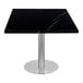 An Art Marble Italian black sintered stone table top with a silver metal pole on a table.