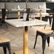 A white Art Marble Furniture Calacatta Sintered Stone table top on a table in a restaurant dining area.