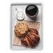 A white Cal-Mil melamine tray with a croissant, cookie, and cup of coffee on it.