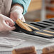 A person putting food into a Pavoni silicone baking mold.