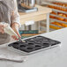 A person using a Pavoni silicone baking mold to make a dessert in a tray.