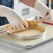 A person using a Pavoni Progetto Crostate stainless steel micro-perforated tart ring to cut a pie.