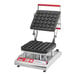A Pavoni Cookmatic pastry and tartlet heated press on a table with a tray of tartlets.