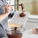 A person using a Pavoni polycarbonate chocolate bar mold to pour chocolate.