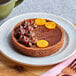 A chocolate tart made using a Pavoni Progetto Crostate tart ring with orange slices on top.