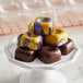 A stack of square chocolates on a white plate.