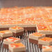 A close up of a cube of food being cut with a Pavoni LT25H6 cutting frame.