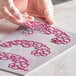 A person using a Pavoni Pavodecor silicone baking mold to cut out heart shapes.