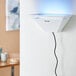 A white wall mounted Lavex Zap N Trap insect light with blue light.