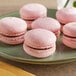 A Pavoni silicone baking mat with filled pink macarons.