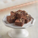 A plate of chocolate cubes with chocolate drizzle.