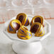 A white plate with chocolate candies made in a Pavoni Praline candy mold. The chocolates have yellow and purple swirls.