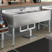 A Regency stainless steel underbar sink with 3 bowls and 2 drainboards.