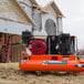 An Industrial Air Contractor gas-powered wheelbarrow air compressor on the ground.