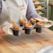 A woman holding a Nordic Ware popover pan with food in it.