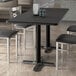 A black rectangular Lancaster Table & Seating table top on a table with chairs in a restaurant dining area.