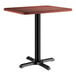 A Lancaster Table & Seating rectangular table with a black base and red mahogany top.