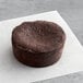 A White Toque flourless chocolate lava cake on a white surface.