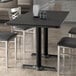 A rectangular black Lancaster Table & Seating table with chairs around it.