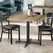 A Lancaster Table & Seating square table with a gray wood finish and chairs in a restaurant dining area.