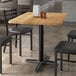 A rectangular wooden table with chairs and salt and pepper shakers.