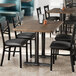 A Lancaster Table & Seating rectangular table with dark walnut finish and chairs in a restaurant.