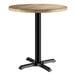 A Lancaster Table & Seating round table with a gray wood finish and black base.