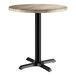 A round table with a gray wood finish top and a black metal pedestal base.