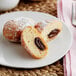 A white plate with two White Toque cocoa-hazelnut filled beignets.