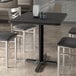 A black rectangular Lancaster Table & Seating table top with chairs around it.