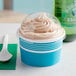A blue Choice paper frozen yogurt cup with a plastic dome lid filled with ice cream.